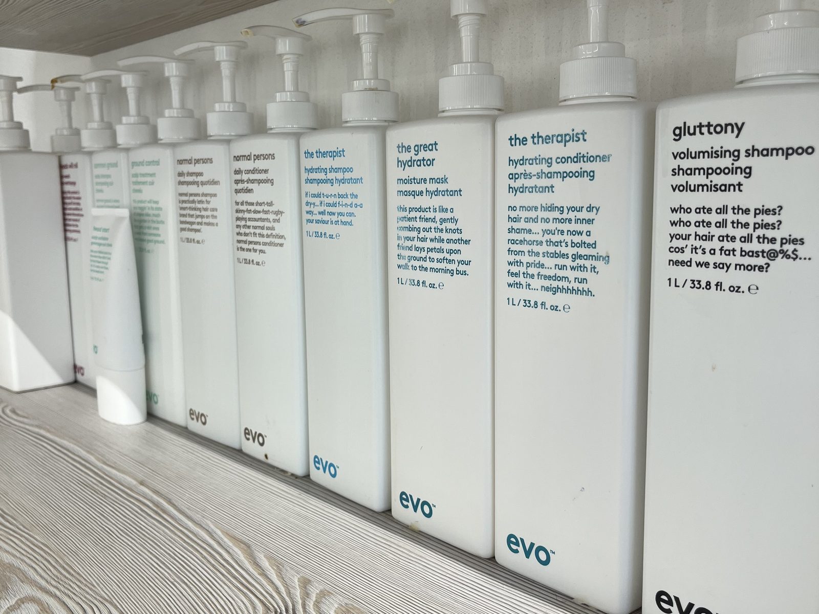 Die evo-Pflegeserie in großen Litergebinden auf dem Holzregal im HAIRLODGE Ellmau.