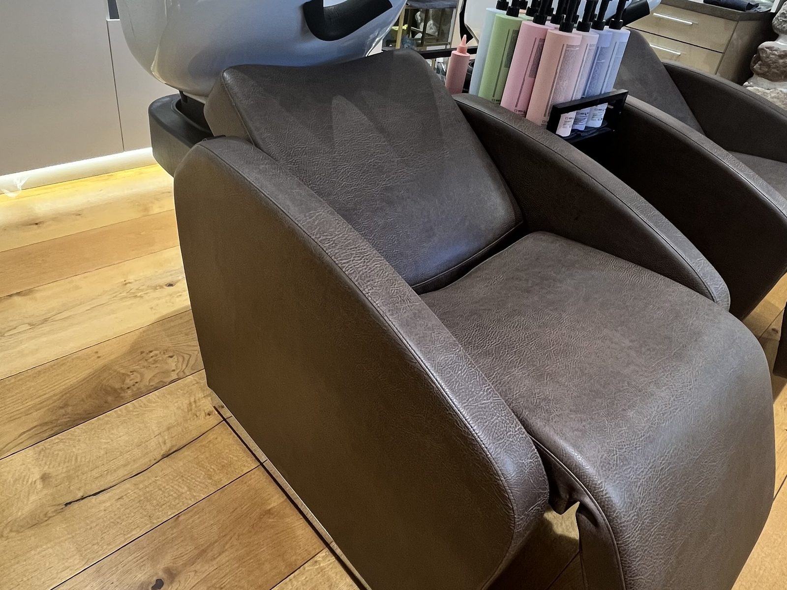 Waschliege im HAIRLODGE Stanglwirt mit weißem Waschbecken und Pflegeprodukten im Hintergrund.