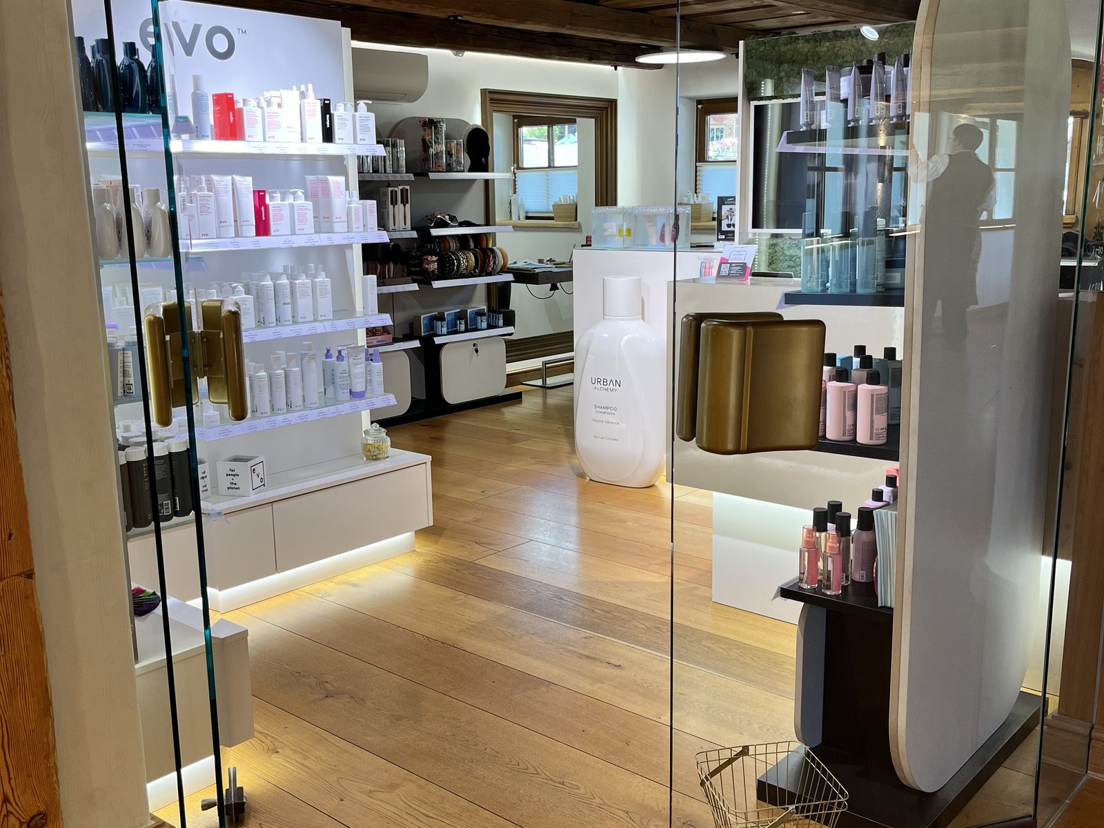 Verkaufsbereich im HAIRLODGE Stanglwirt mit beleuchteter evo Regalwand, Urban Alchemy Display und Bürstensortiment.